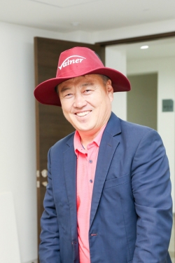 ‘바이네르’ 모자를 쓴 김원길 대표가 환하게 웃으며 기념촬영하고 있다.