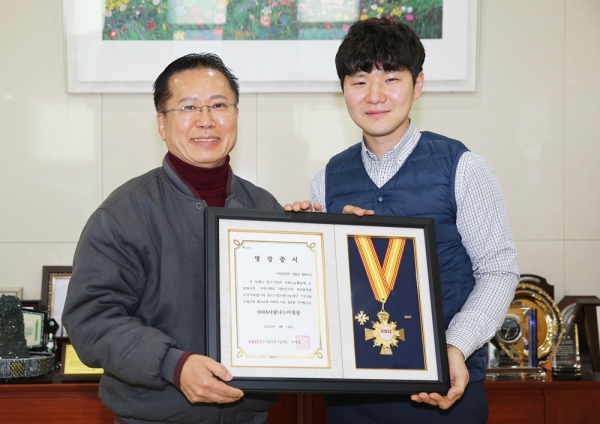 김창길 금강쿼츠 대표가 복지발전에 이바지한 공으로 중소기업사랑나눔재단 직원으로부터 명장증서를 전달받고 있다.