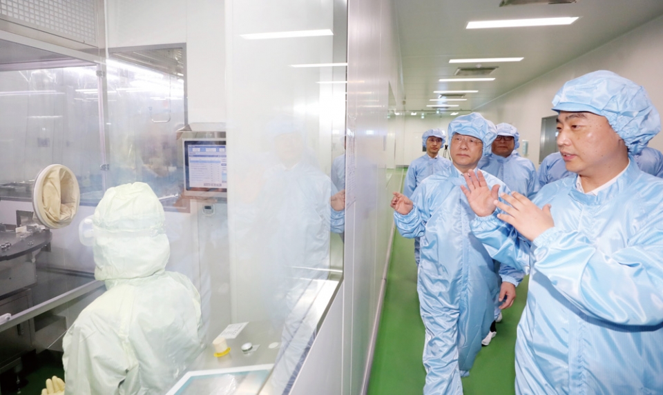 홍남기 경제부총리 겸 기획재정부 장관(오른쪽 두번째)이 지난 13일 충북 청주시에 있는 코로나19 관련 제약회사를 방문해 생산라인을 둘러보고 있다.