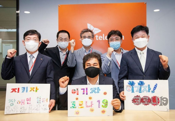 체결식 참석자들이 한국장애인고용공단이 제작한 코로나19 극복 메시지를 들고 결의를 다지는 모습