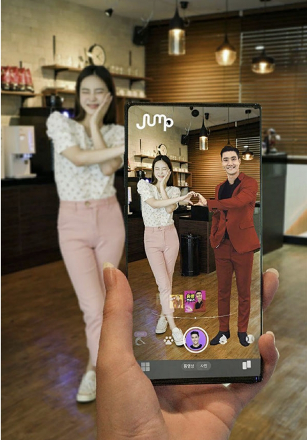 SK텔레콤 홍보모델이 점프 AR 앱에서 K팝 그룹 슈퍼주니어 멤버 최시원씨 이미지를 소환해 함께 셀카를 찍고 있다.