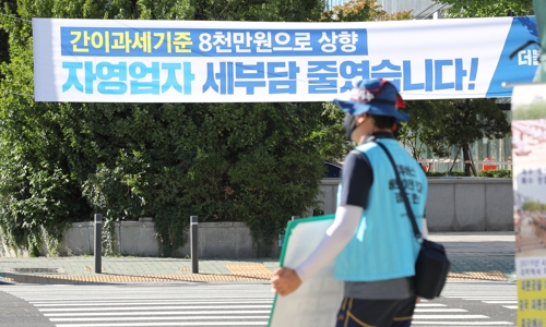 지난 26일 서울 여의도 국회 앞에 '간이과세기준 8천만원으로 상향. 자영업자 세부담 줄였습니다'라고 적힌 더불어민주당의 플래카드가 걸려있다.