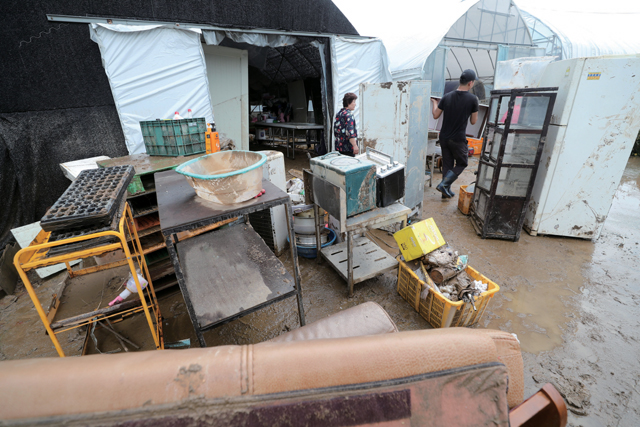 지난 5일 충남 천안시 동남구 병천면 가전리 한 비닐하우스 농가에서 농민들이 물에 잠긴 물품을 빼내는 등 수해 복구 작업을 하고 있다