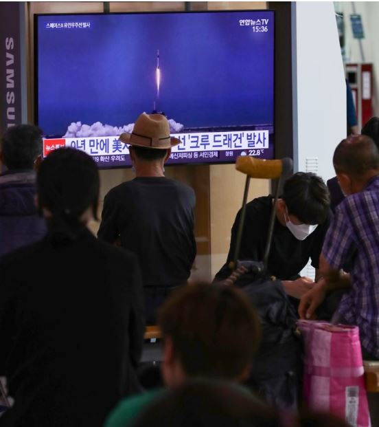 31일 오후 서울역에서 시민들이 미국의 첫 민간 유인우주선 '크루 드래건'을 실은 팰컨9 로켓의 발사 관련 보도를 보고 있다.