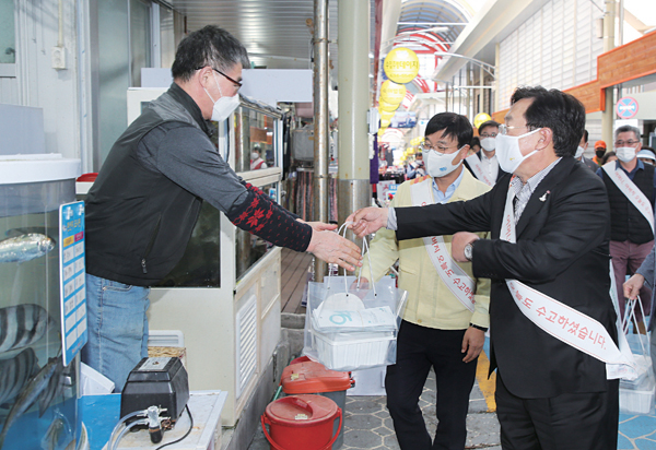 지난 19일 거제 고현시장을 찾은 김기문 중소기업중앙회장(오른쪽)과 변광용 거제시장(가운데)이 한 상인에게 삼계탕과 방역물품을 전달하고 있다.