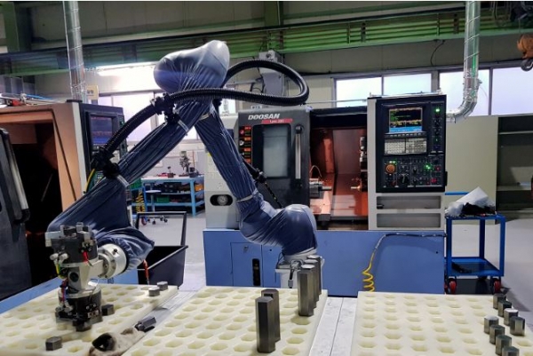 두산이 협력사 스마트공장 구축을 위해 도입한 협동로봇이 생산현장에서 작업을 수행하고 있다. [두산 제공]
