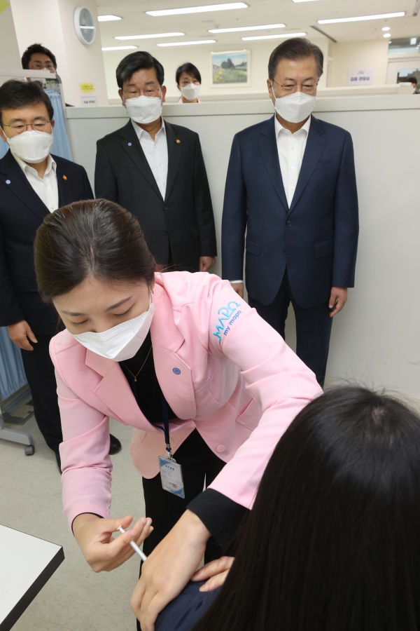 문재인 대통령이 코로나19 백신 접종 첫날인 2월26일 서울 마포구보건소를 방문해 아스트라제네카 백신을 접종 받는 한 종사자를 지켜보고 있다.