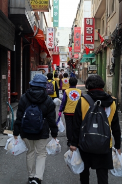 적십자 봉사원들이 지난 9일 서울 용산구 후암동 일대에서 쪽방촌 거주민에게 밑반찬을 전달하기 위해 이동하고 있다. [제공=대한적십자사]