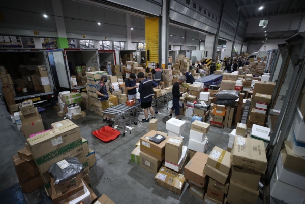 택배노조가 파업을 철회한 가운데 18일 송파구 서울복합물류센터에서 관계자들이 물품을 옮기고 있다.