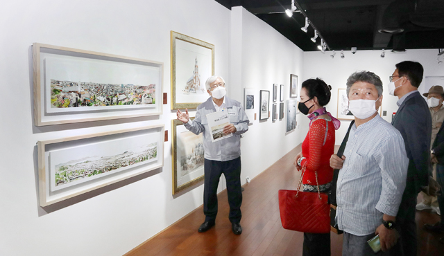 이경호 영림목재 회장이 ‘인천’을 주제로 한 그림을 중소기업중앙회 문화경영위원회 위원들에게 설명하고 있다.