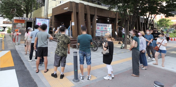 24일 서울 송파구 송파구보건소에 마련된 코로나19 선별진료소에서 시민들이 검사를 받으려 대기하고 있다.