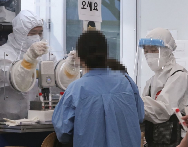 24일 서울 송파구 송파구보건소에 마련된 코로나19 선별진료소에서 의료진이 검사를 진행하고 있다.
