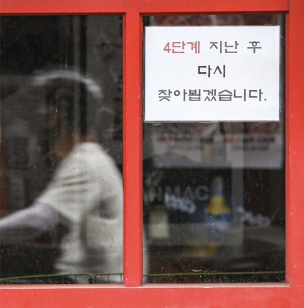 정부가 수도권의 사회적 거리두기 4단계, 비수도권 3단계 유지를 발표한 20일 서울 서대문구 신촌 거리의 한 음식점에 '거리두기 4단계' 후 영업을 재개한다는 안내문이 붙어 있다.