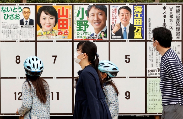 일본 중의원(하원) 선거 투표일인 31일 수도 도쿄의 투표소 밖에서 한 유권자가 선거 벽보를 살펴보고 있다.