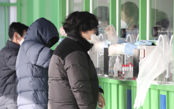 지난 12일 오후 서울 마포구 월드컵공원 평화광장에 마련된 임시선별검사소를 찾은 시민들이 검체 채취를 받고 있다. [제공=연합뉴스]