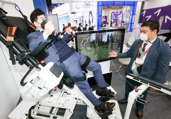 지난 10일 서울 강남구 코엑스에서 열린 ‘국제의료기기·병원설비전시회’(KiMES) 한 부스에서 관계자가 기립경사 재활훈련 로봇을 시연하고 있다.