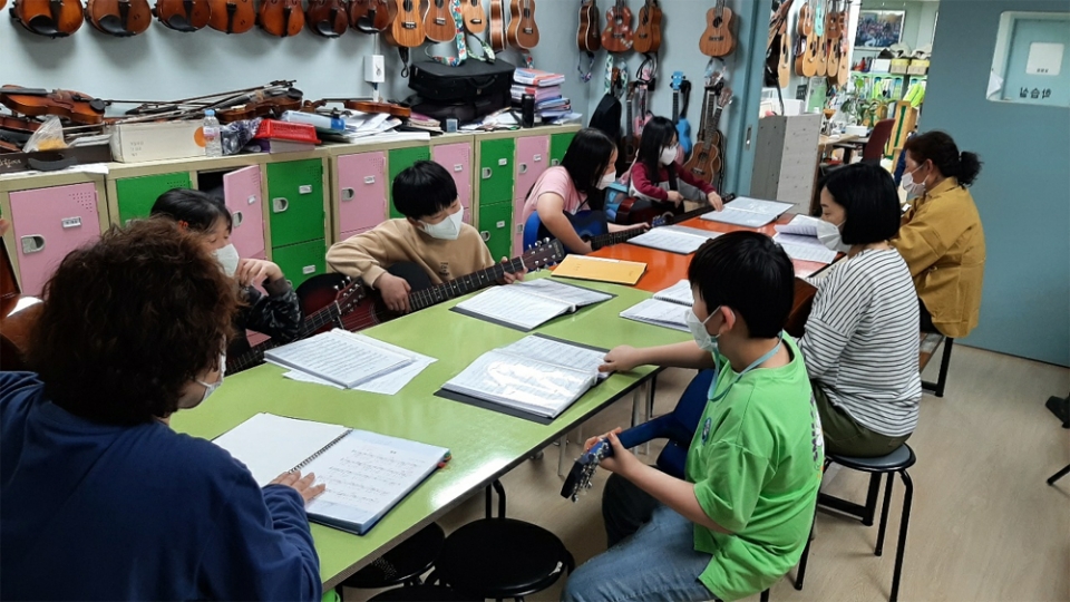 운호지역아동센터 아동들이 기타 연주 수업을 받고 있다.