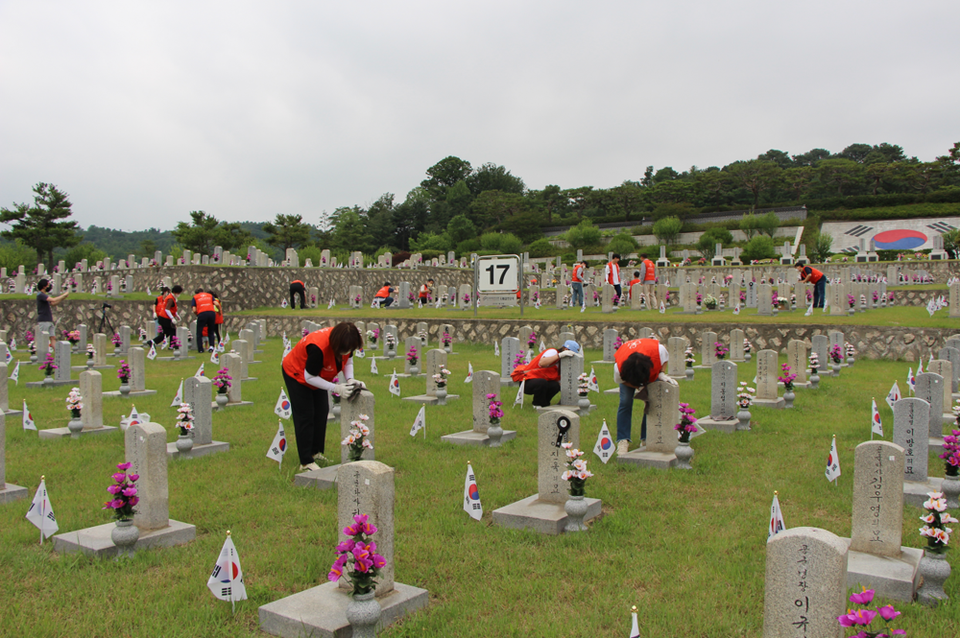 지난 6월 18일 국립서울현충원에서 진행된 중소기업사랑나눔재단의 제45차 연합봉사활동에 참가한 봉사자가 순국선열들의 묘비를 정성스럽게 닦고 있다.