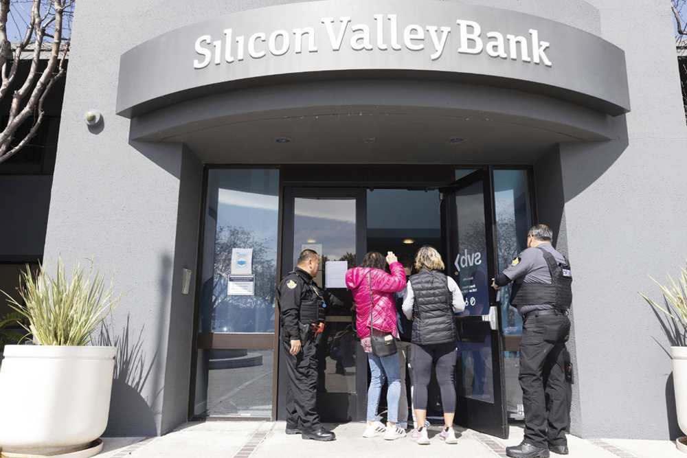 지난 13일(현지시간) 미국 캘리포니아주 샌타클래라 실리콘밸리은행(SVB) 본점의 보안요원들이 예금주들을 입장시키고 있다.