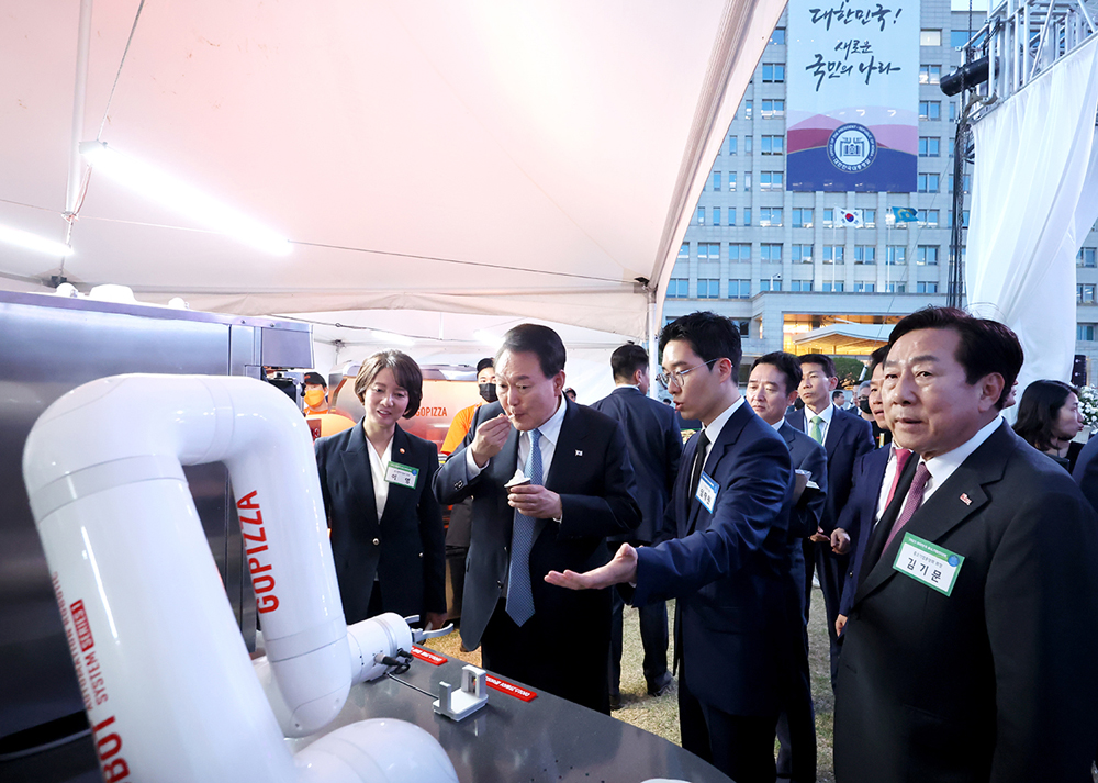 임재원 고피자 대표가 윤석열 대통령에게 자체 개발한 조리로봇을 설명하고 있다.